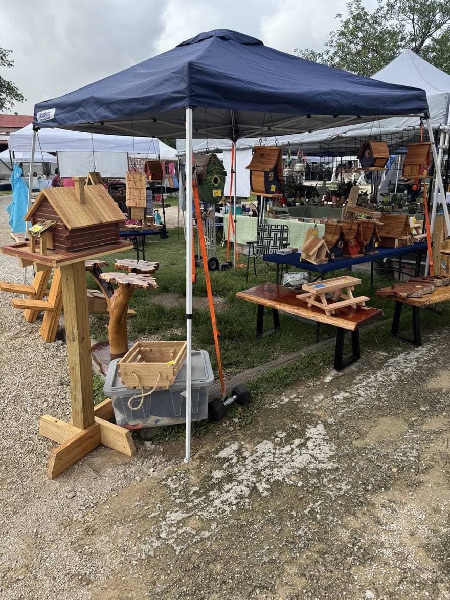 The Taddog Woodcraft booth under a blue canopy at market