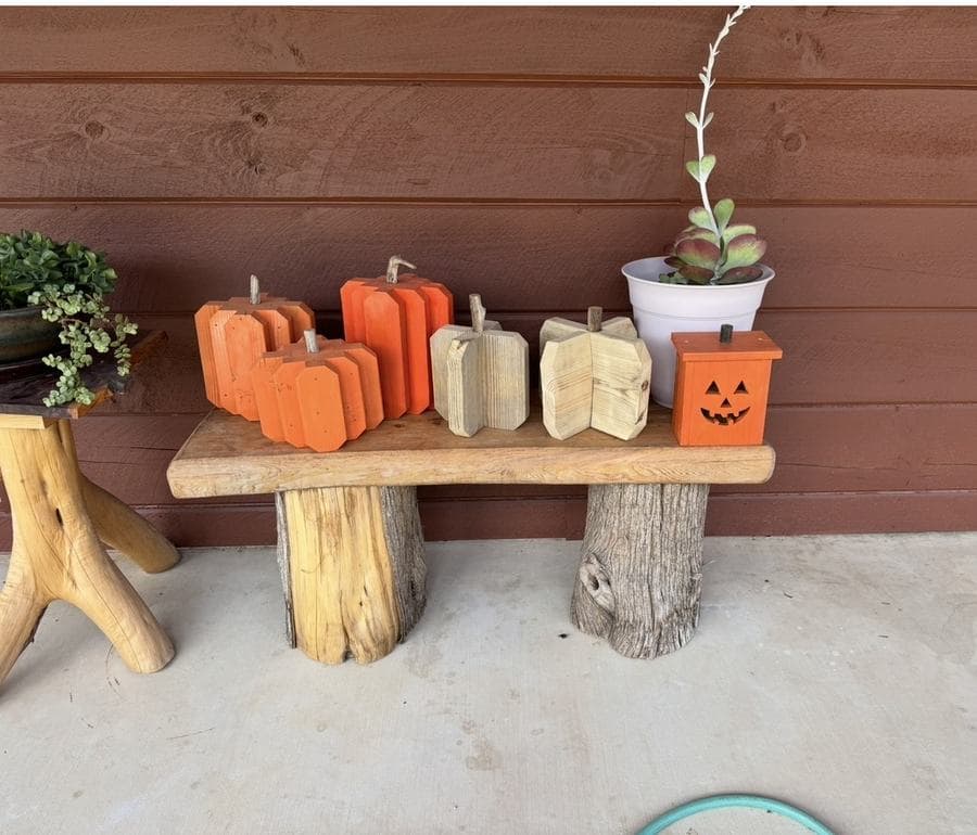 Painted wood pumpkins on a cedar bench