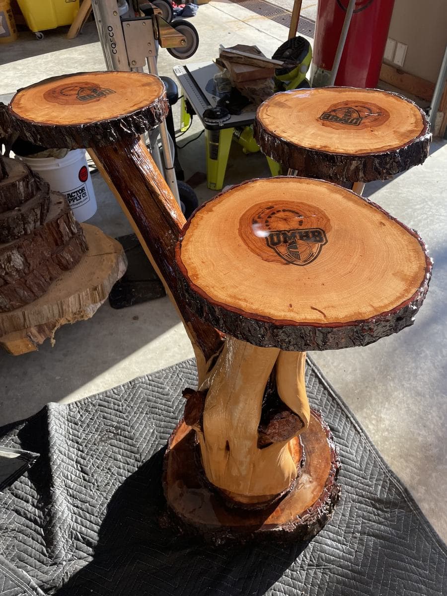 Three-tier log party table with epoxy-sealed logo tops