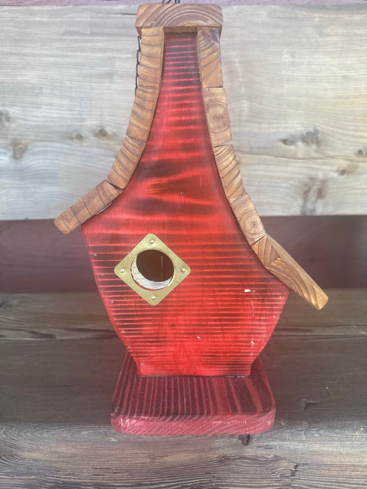 Red-finished shou sugi ban cedar birdhouse with shingled roof